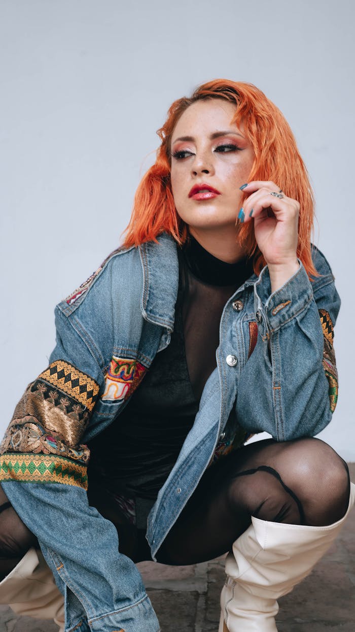 services-01 Trendy female model in a vibrant denim jacket and white boots posing indoors.